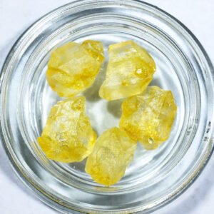 ein Glas mit fünf THC Kristallen, mit gelber Farbe sind zu sehen