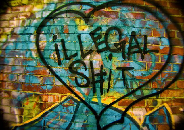 hier ist eine bunt besprayte Wand zu sehen auf die ein schwarzes Herz gemalt ist mit der Innschrift: illegal Shit. Cannabis als illegale Droge ist zum Beispiel so ein Shit :).