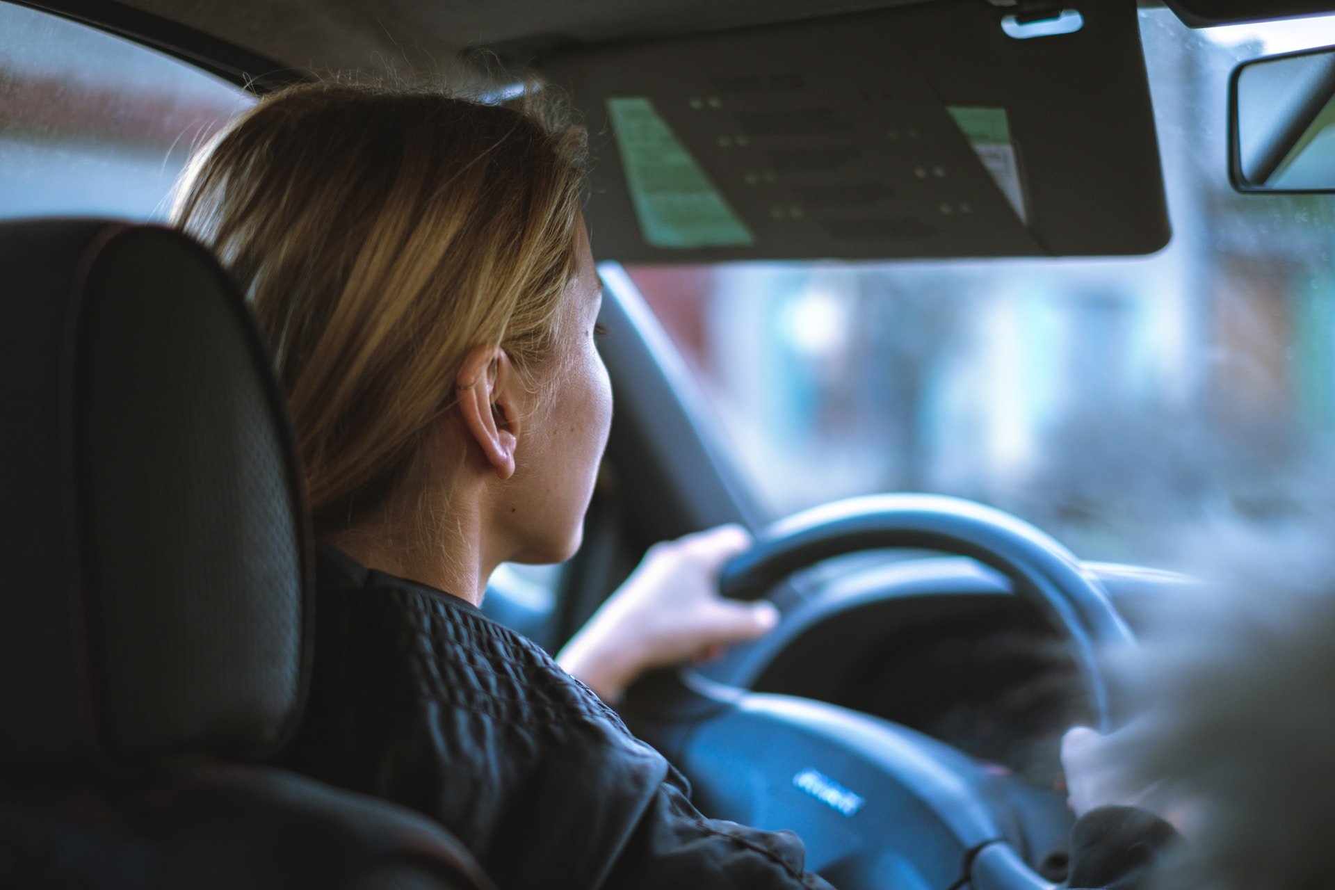 Eine Frau sitzt hinter dem Steuer eines Autos. Sie erhält hoffentlich kein Führerscheinentzug durch Cannabiskonsum