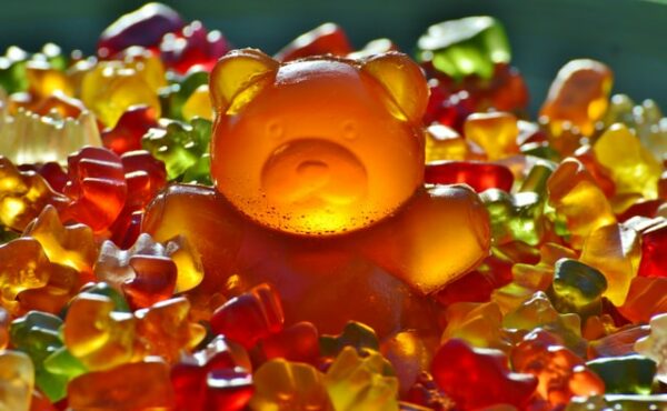 ein großes orangenes Fruchtgummi ist zu sehen, inmitten von vielen kleinen. So könnten auch CBD Fruchtgummis aussehen.
