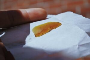 Hier ist ein weißes Tuch mit einem Stück orange farbenen Haschisch zu sehen. 