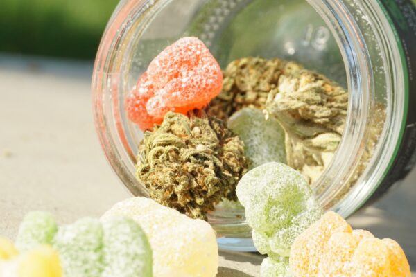 Hier sieht man ein umgelegtes Glas, in dem Gummibärchen mit Cannabis gemischt sind.