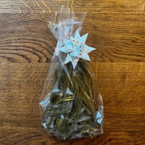 Hier ist ein Plastiktütchen mit Hanfnudeln und einem Fröbelstern zu sehen.