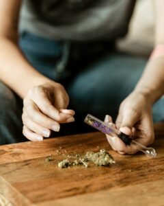 Eine Frau befüllt eine kleine Pfeife mit Cannabis