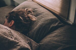 Eine Frau liegt im Bett und schläft. Vielleicht nahm sie Cannabis bei Schlafstörungen ein.