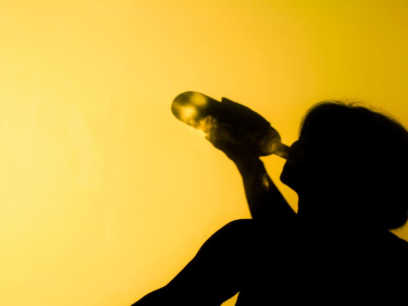 Eine Frau trinkt aus einer Alkoholflasche