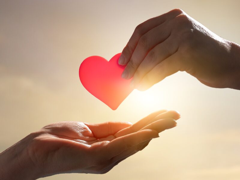 Eine Hand gibt der anderen ein Herz