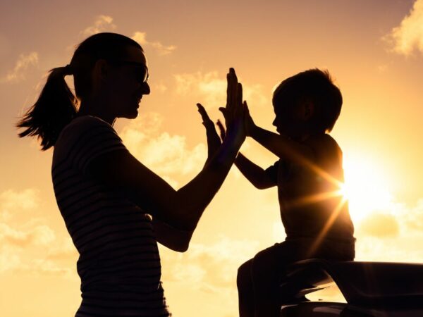 Eine Frau schlägt mit ihren Kind ein - High Five