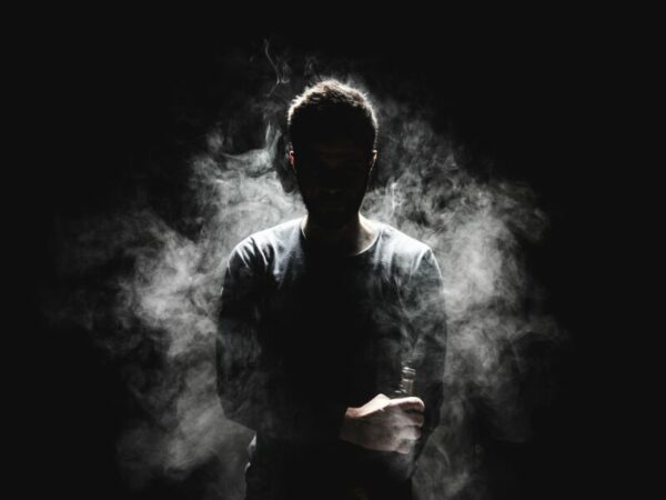 Ein Mann steht im Dampf einer E-Zigarette. Die Nutzung dieser E-Vapes ist gefährlich. 