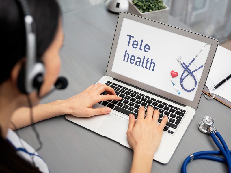 Die Zukunft der Telemedizin - wie wird diese in Deutschland aussehen? Eine Frau sitzt vor einem Laptop mit der Aufschrift Telehealth