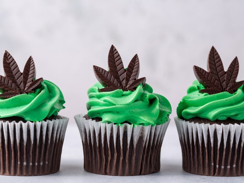 Es ist wichtig, die richtige THC Dosis bei Edibles zu kennen und zu bestimmen. Hier sieht man drei Cupkakes mit Hanfblatt Schokolade darauf