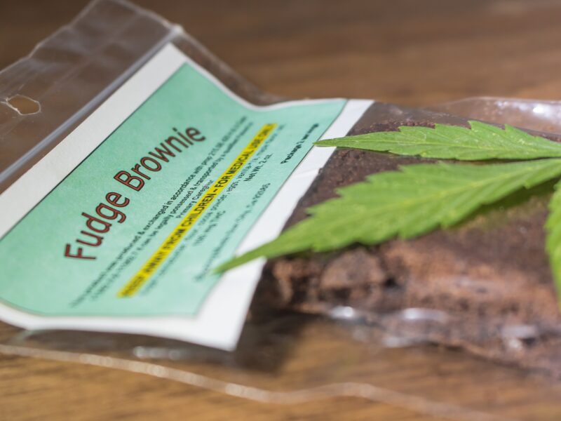 Die Qualitätskontrolle bei Edibles ist wichtig. Hier sieht man einen Fudge Brownie in einer Verpackung mit einem Hanfblatt.