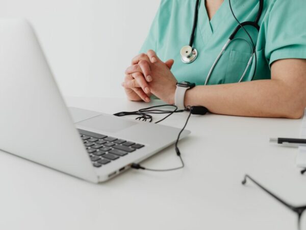Eine Ärztin sitzt vor einem Laptop und nutzt die Telemedizin 