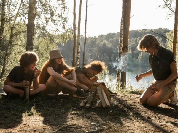 Jugendliche sitzen um ein Lagerfeuer