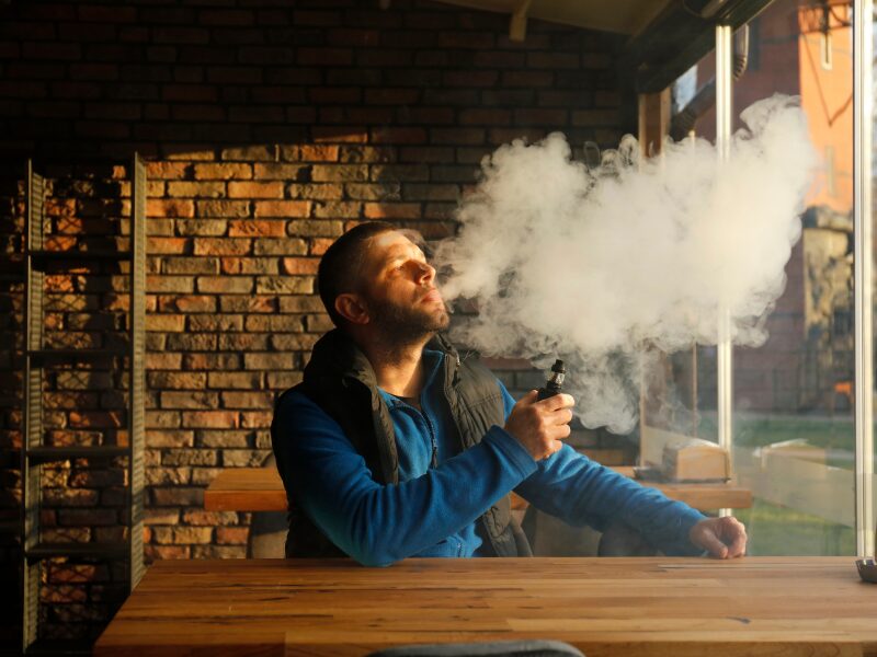 Kiffen im Café. Ein Mann sitzt mit einem Vape im einem Café. Ist das die Zukunft von modernen Konsumräumen?